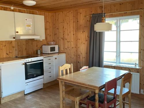 cocina con mesa y pared de madera en Sandvikens Fiskeläge Ulvön en Ulvöhamn