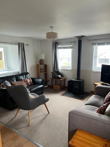 a living room with a couch and a chair at Eviedale Cottages ltd in Evie