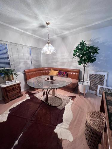 a living room with a couch and a glass table at Good Old Days Main Retro in Vancouver