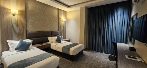 فندق ليان بارك Lian Park Hotel في الخبر: غرفة فندقية بسريرين وتلفزيون بشاشة مسطحة