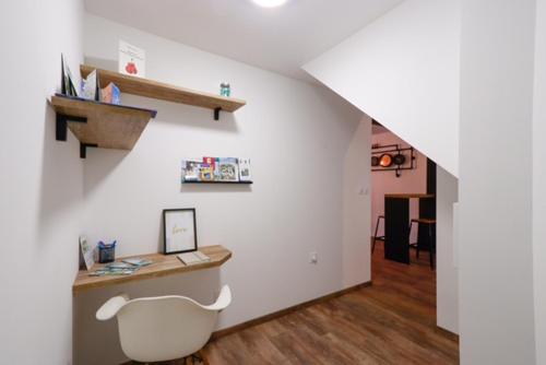 a white room with a desk and a staircase at Le Ti'chey-toi in Tichey