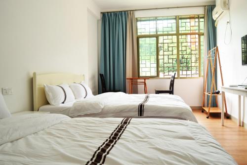 um quarto com 2 camas e uma janela em Longyan Yongding Tulou Mengtian Inn em Yongding