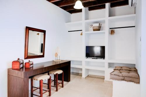 a room with a vanity and a mirror and a tv at Anesis Traditional Rhodian House in Kattavía