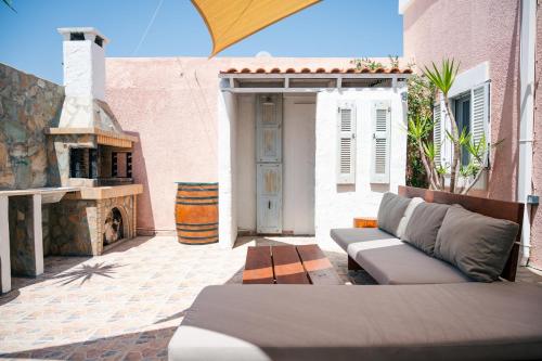 a outdoor patio with a couch and a fireplace at Anesis Traditional Rhodian House in Kattavía