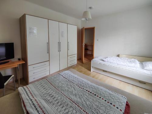 sypialnia z łóżkiem, szafkami i telewizorem w obiekcie FEWO Jänschwalde II w mieście Jänschwalde Ost