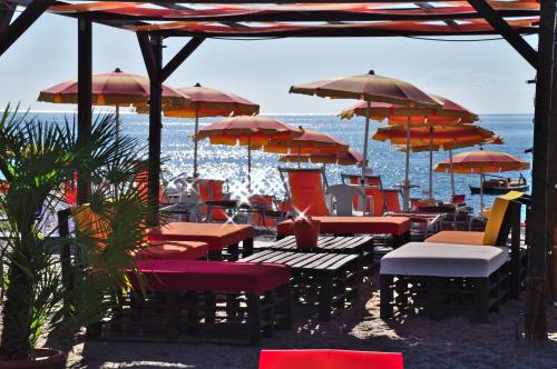 a group of tables and chairs with umbrellas on the beach at Grand Hotel President in Siderno Marina
