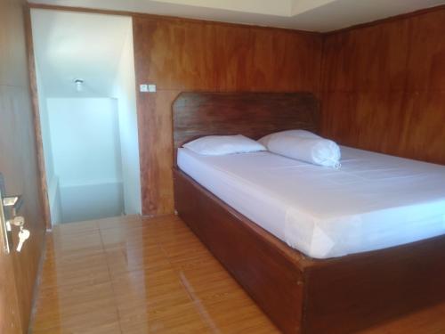 uma cama com duas almofadas num quarto em Rain homestay em Selong