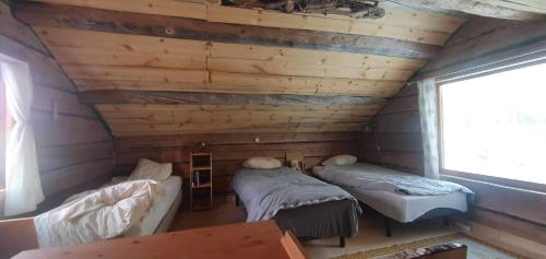 a room with two beds in a log cabin at Gemütliche Blockhütte mit Sauna in Jörn