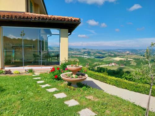 a flower pot sitting in the grass next to a house at Villa Bellavista Alba, B&B in Alba