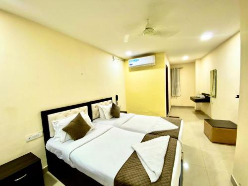 a bedroom with a large bed and a bathroom at Hotel Sky Park in Shamshabad