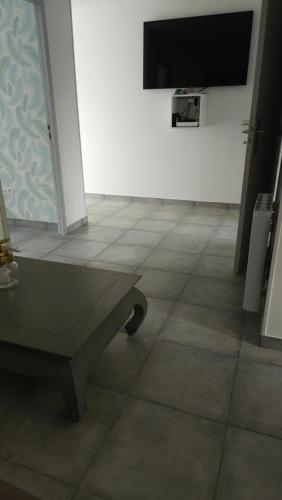 a room with a tiled floor and a flat screen tv at Au Champ Fleuri in Bracieux