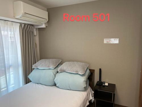 um quarto com uma cama com uma placa de quarto na parede em SkyHotel Ryogoku 駅徒歩4分 em Tóquio