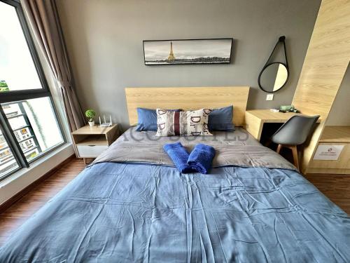 ein Schlafzimmer mit einem großen blauen Bett mit blauen Kissen in der Unterkunft K Avenue 2-3PAX Studio Homestay by Zaco Suites in Kota Kinabalu
