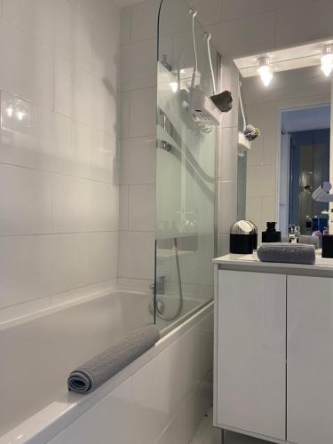 une salle de bain blanche avec une baignoire et un lavabo dans l'établissement Bord de mer, terrasse, tout à pieds, à Cannes