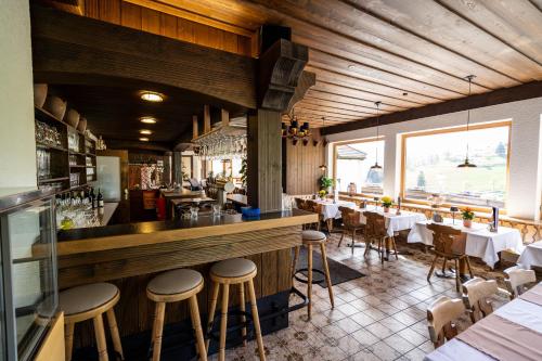 un ristorante con bar con tavoli e sedie di Schwarzwald Hotel Wiedenerhof a Wieden