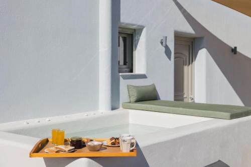 a room with a table and a green bench at Windmillside Luxury Villas in Emporio Santorini
