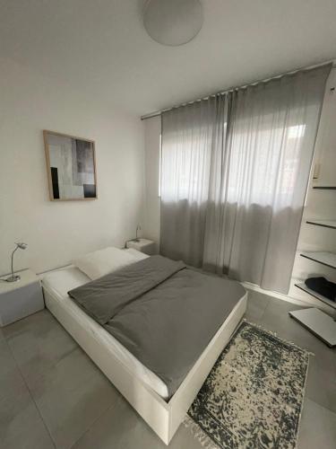 a white bedroom with a bed and a window at City Loft in Freudenstadt