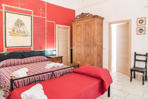 a bedroom with two beds and a red wall at Villa Giulia - Vesuvio Guest House Pompei Sorrento in Boscotrecase