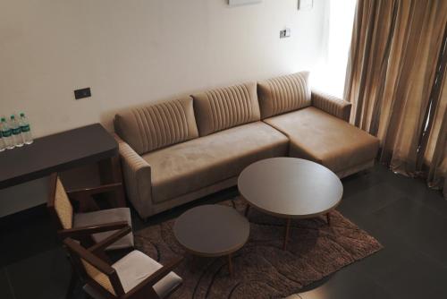 a living room with a couch and a table and chairs at Bir Valley Retreat in Bīr