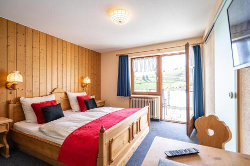 una camera con un grande letto e una finestra di Schwarzwald Hotel Wiedenerhof a Wieden