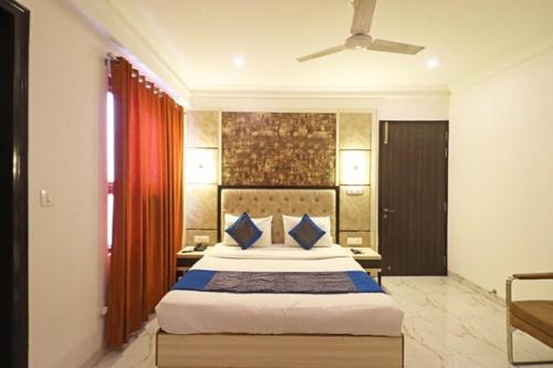 1 dormitorio con 1 cama grande con almohadas azules en Hotel The Almora Residency Near IGI Airport, en Nueva Delhi