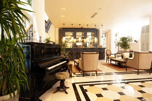 a living room with a piano and chairs at Rasim Palas - Adults Only in Cesme
