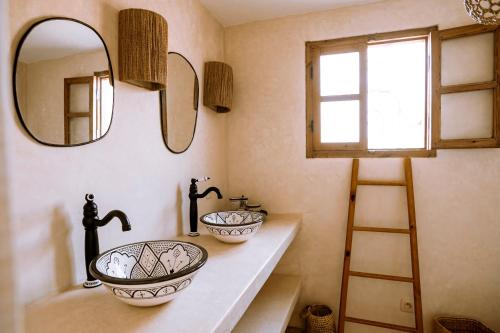 a bathroom with two sinks and a mirror at Villa Madame Babouche, chambre Taziri, SdB privative in Oulad el Madani