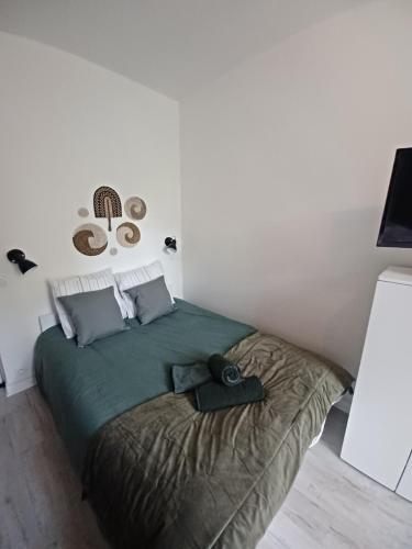 une chambre avec un lit avec une couette verte dans l'établissement Studio M proche des thermes de Royat Chamalières à pieds, à Chamalières