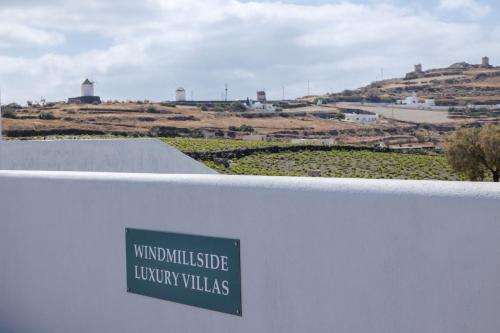 a sign on the side of a building with a view of a town at Windmillside Luxury Villas in Emporio Santorini