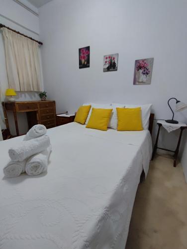 a bedroom with two beds with yellow pillows at Summer studios 1 in Koroni