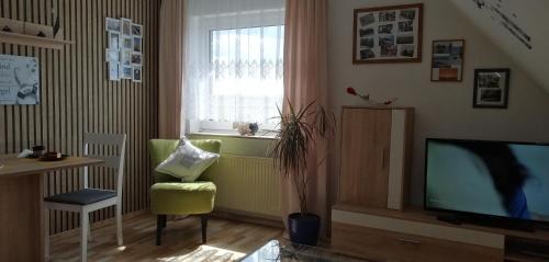 uma sala de estar com televisão e janela em Haus Valentin em Dornum