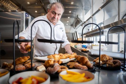 a man standing in a kitchen preparing food at Hotel & Spa Convento San Francisco in Soria