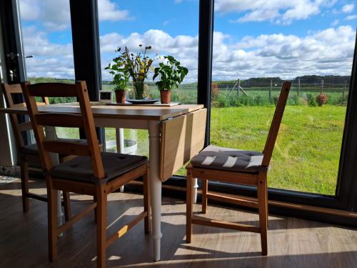 ein Tisch und zwei Stühle mit Blick auf ein Feld in der Unterkunft Chalets des prés-village in Bussy-le Repos
