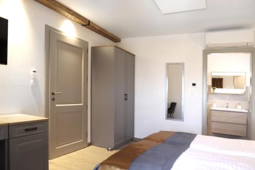 a white bedroom with a bed and a bathroom at Vila Ulika in Malinska