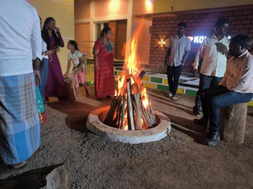 a group of people standing around a fire pit at Kanna Garden by Bodhi Bungalows in Kolli Hills