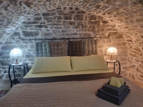 a bedroom with a bed with two lamps on two tables at Villa Olive Old Qeparo in Qeparo