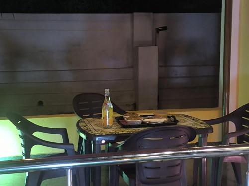 a table with chairs and a bottle and a plate of food at Kanna Garden by Bodhi Bungalows in Kolli Hills