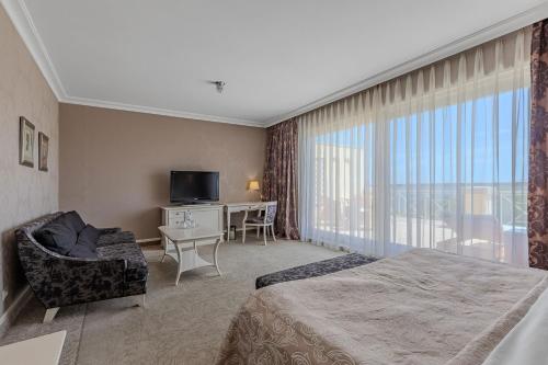 a hotel room with a bed and a television at Palace Del Mar in Odesa