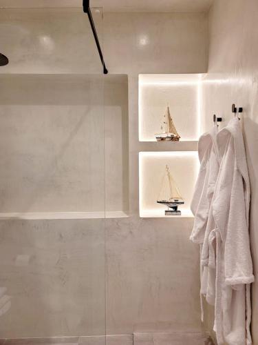 a bathroom with white towels and a glass shower at Artis Blue Relax in Himare