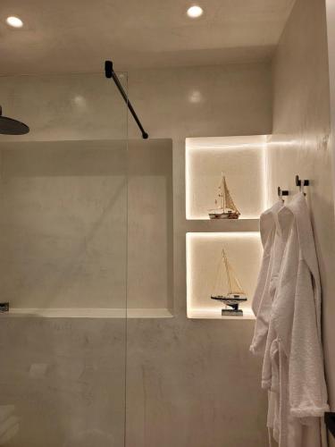a bathroom with a glass shower with a model of a ship at Artis Blue Relax in Himare