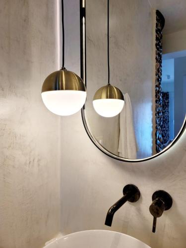 two lights above a bathroom sink with a mirror at Artis Blue Relax in Himare
