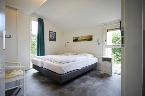 a bedroom with a large bed and a window at Vakantiepark Hof van Zeeland in Heinkensand