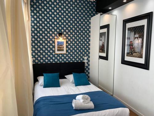a small bedroom with a bed with blue pillows at 115 - Urban Vuitton Saint Denis in Paris