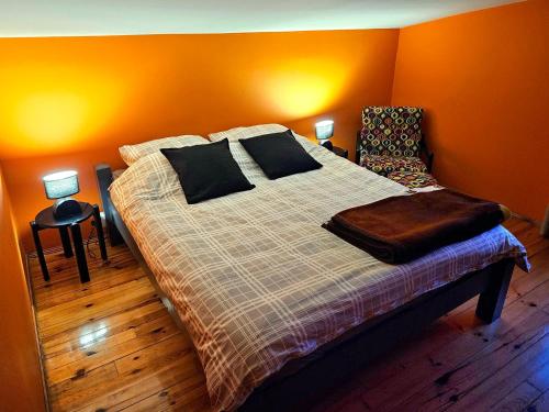 ein Schlafzimmer mit einem Bett mit orangefarbenen Wänden in der Unterkunft Dom letniskowy przy lesie nad jeziorem in Rogowo