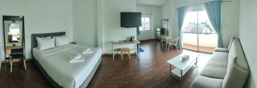 een slaapkamer met een bed en een woonkamer bij โรงแรมนราพัตรา in Narathiwat