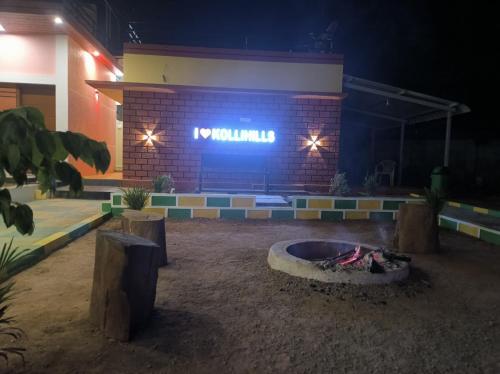 a brick building with a fire pit in front of it at Kanna Garden by Bodhi Bungalows in Kolli Hills
