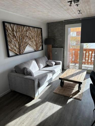 un salon avec un canapé et une table basse dans l'établissement Au Myosotis, cosy au pied des pistes avec vue et cœur de station, à Les Deux Alpes