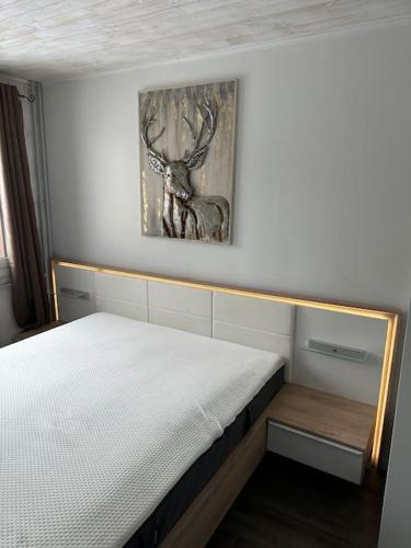 - une chambre dotée d'un lit avec une photo de cerf sur le mur dans l'établissement Au Myosotis, cosy au pied des pistes avec vue et cœur de station, à Les Deux Alpes