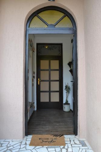 una porta con un tappetino di benvenuto davanti di Apartman Gluhović a Sombor