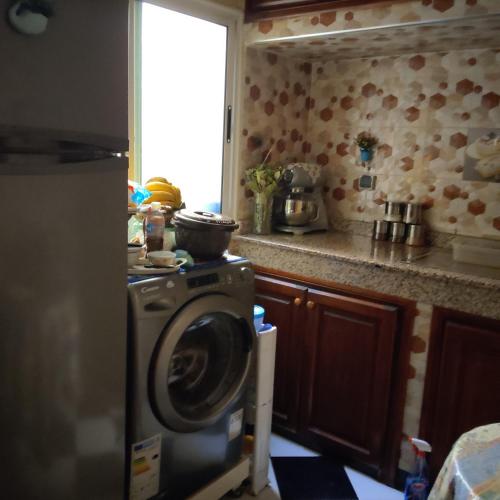 eine Küche mit einer Waschmaschine und einem Fenster in der Unterkunft Dar Al Menzeh in Beni Mellal